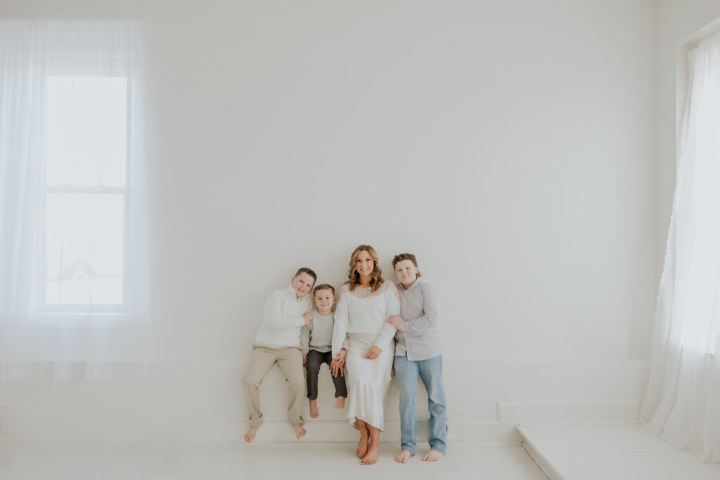 Family sitting together in a bright white room.